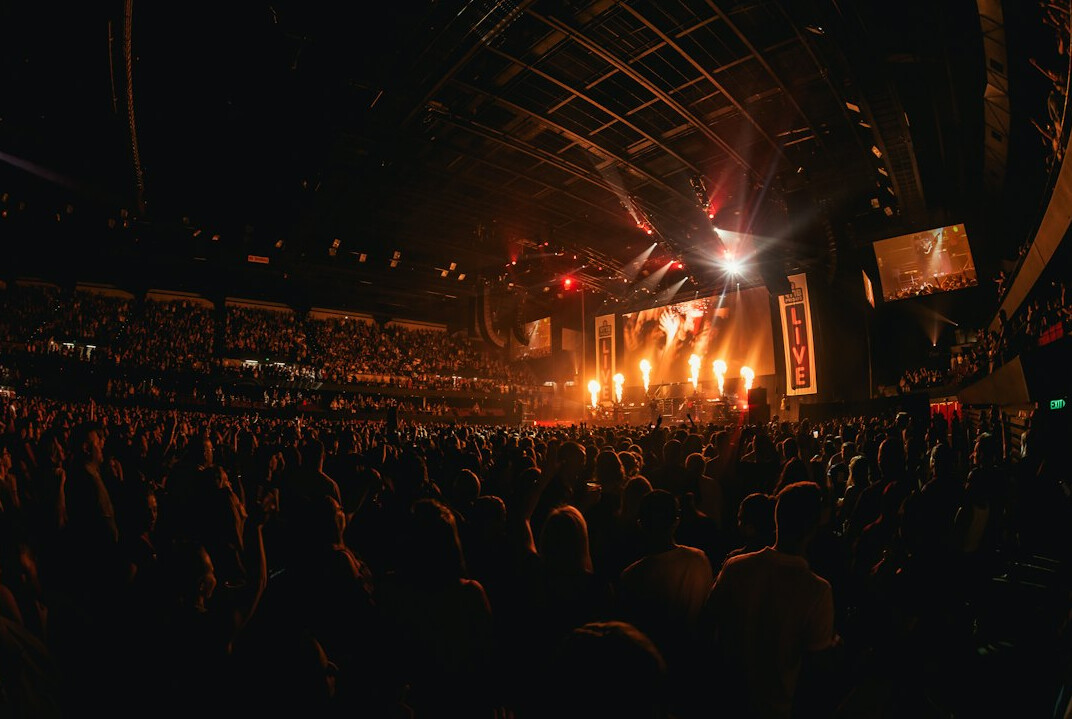 Concert audience seen from behind with warm stage lights