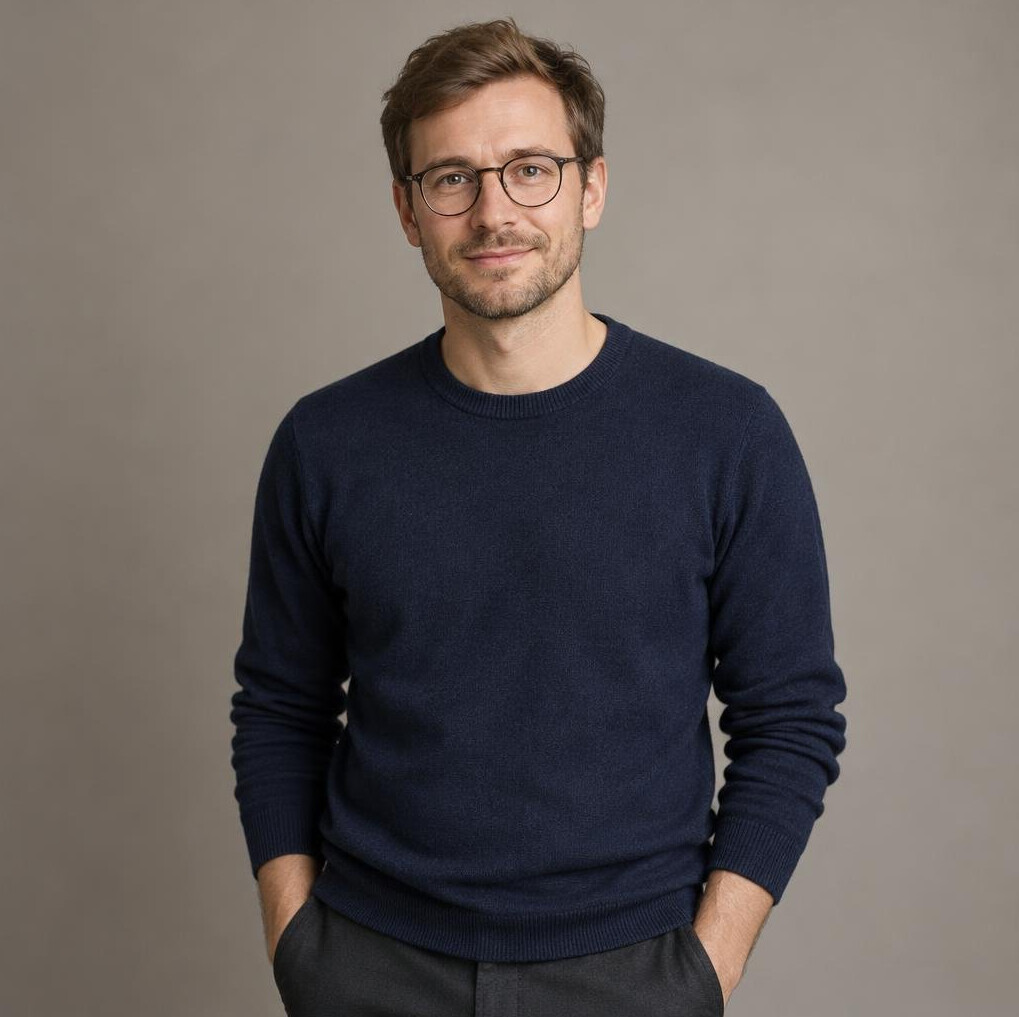 Portrait of a young German man with glasses in a navy sweater