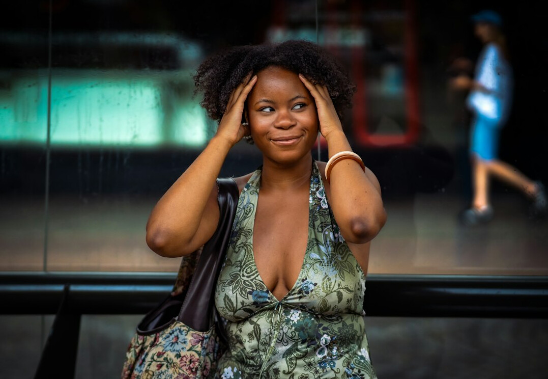 Portrait of a Black German woman with natural hair in a sage green blouse