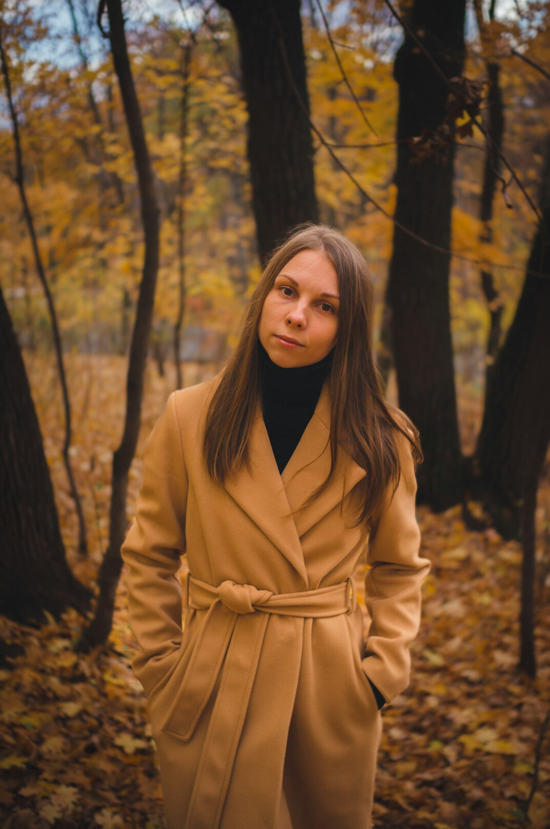 Portrait of a Turkish-German woman with long dark hair in a camel coat